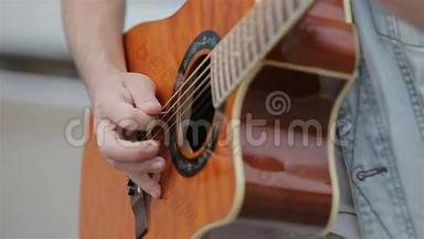 弹声吉他的年轻人。 一个吉他手在弹声吉他。 慢动作